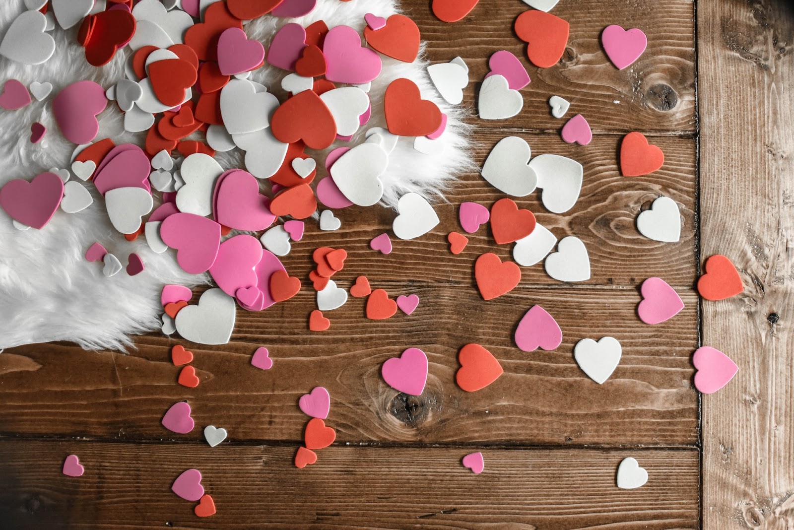 A wooden floor covered in hearts in lots of different sizes, coloured white, pink and red