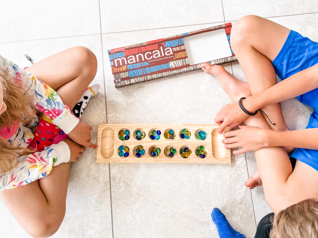 A wooden game being played by 2 children