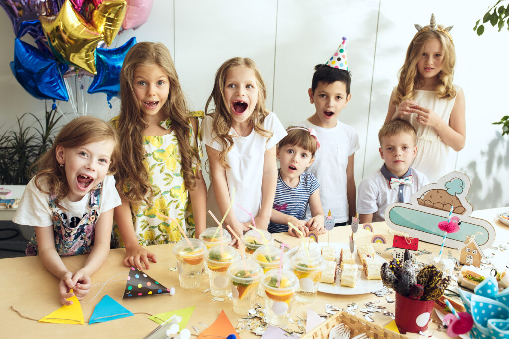 A group of children posing for a photo at a birthday party, capturing the joyful entertainment.