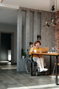 A woman in a wheelchair ensuring accessibility laws on her laptop.