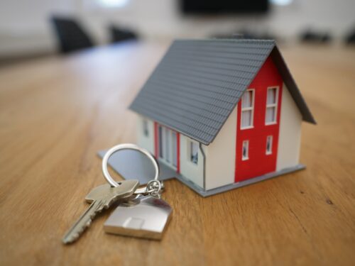 A model of a house with keys on a table available for buying.