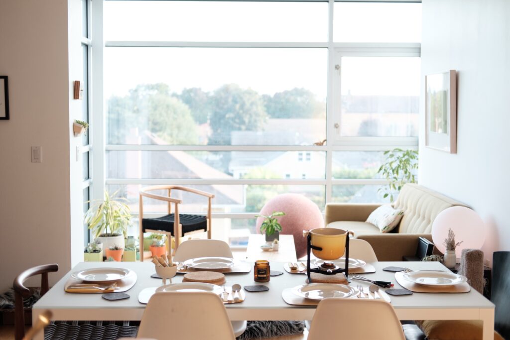 A dining table in a room with a large window that transforms the spaces.