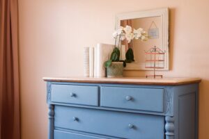 The blue dresser in the room adds a touch of ultimate comfort, while the mirror steps up the room's transformation.