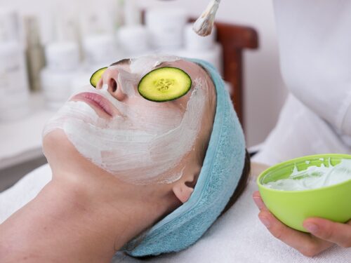 A woman receiving a skin-pampering cucumber face mask at a high-quality spa.