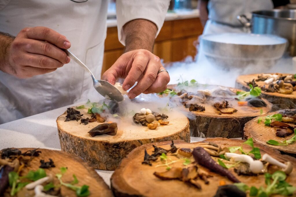 A Home Chef is gracefully preparing food on a wooden board.