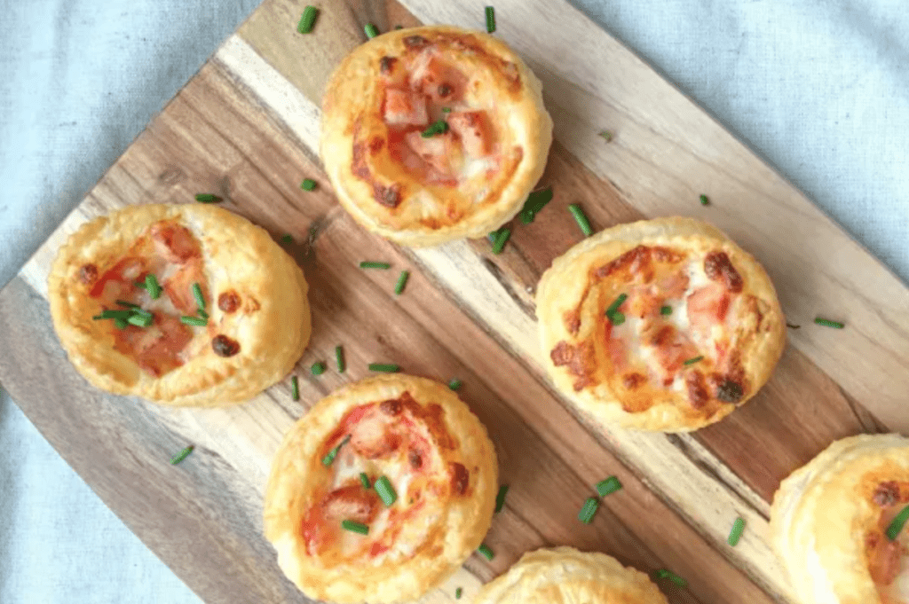 Puff pastry ham and cheese party nibbles on a wooden board