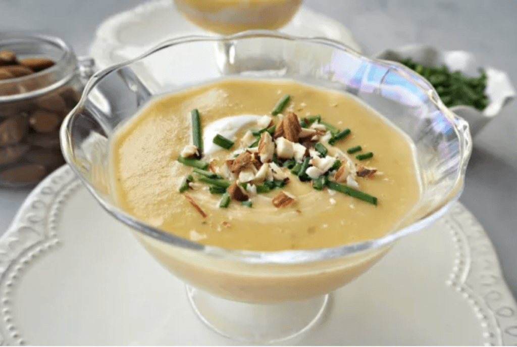 A glass bowl of leek an sweet potato soup